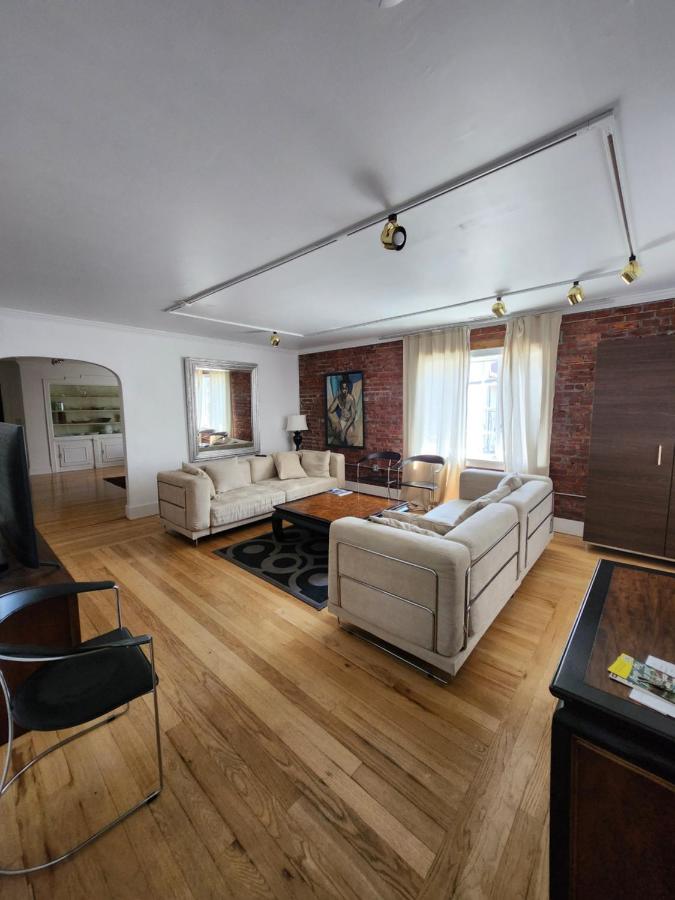 Staged apartment living room with exposed brick and wood floors